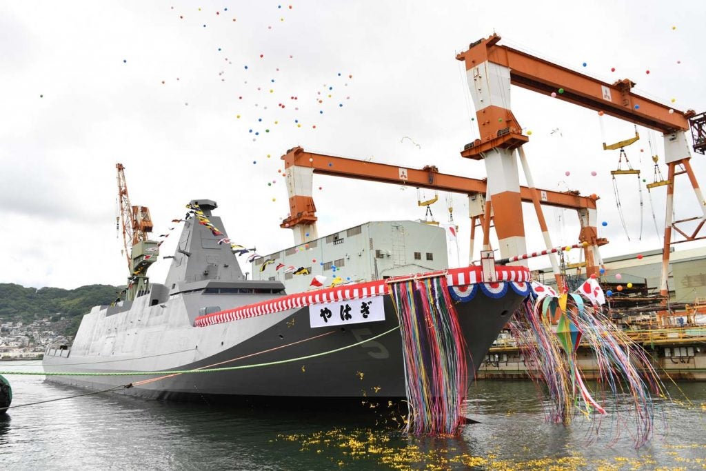 Yahagi, adornedwith ribbons and a banner with her name, floats out of the drydock with balloons to celerate her launch.