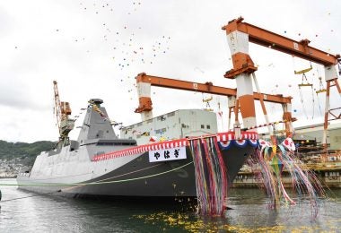 Yahagi, adornedwith ribbons and a banner with her name, floats out of the drydock with balloons to celerate her launch.