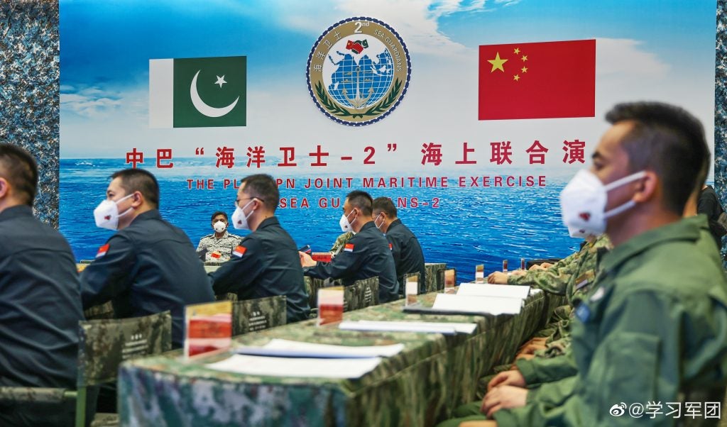 Officers of the Chinese and Pakistan navies sit in a conference room