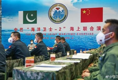 Officers of the Chinese and Pakistan navies sit in a conference room