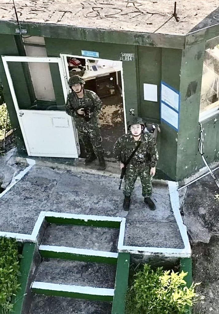 Two Taiwanese Soldiers look up at the offending drone