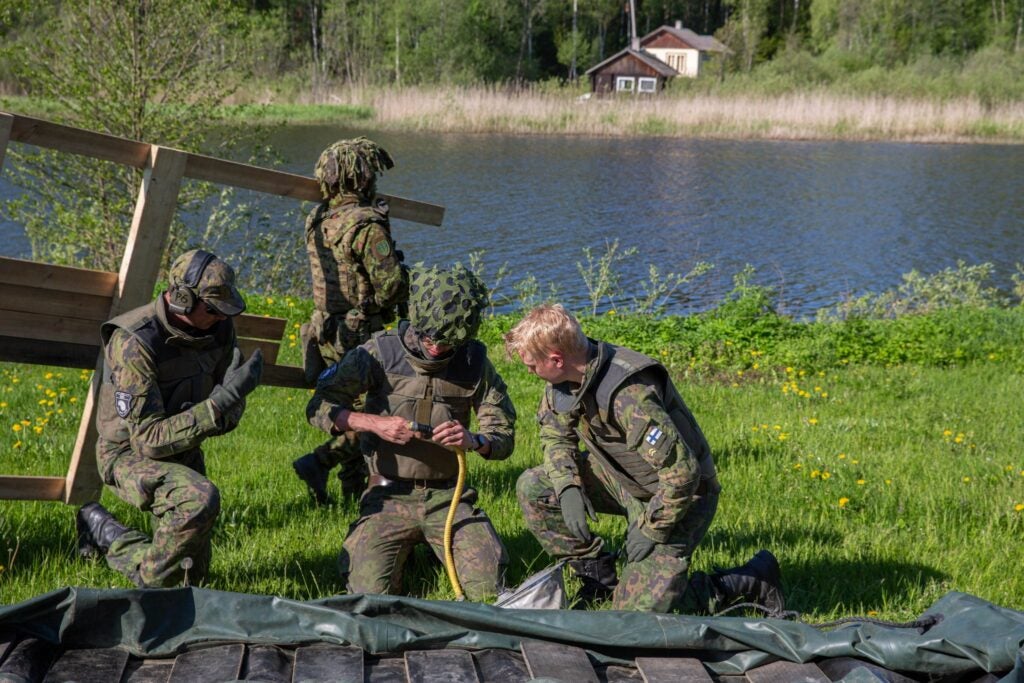 A Finnish soldier is seen helping to prepare a bridge for a lake crossing during Exercise Hedgehog 22 in Estonia (Finnish Army)