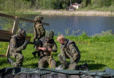 A Finnish soldier is seen helping to prepare a bridge for a lake crossing during Exercise Hedgehog 22 in Estonia (Finnish Army)