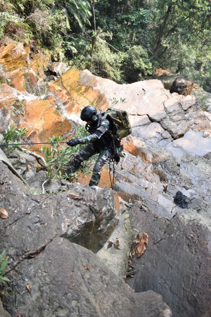 An operator with the joint French-Malaysian team rappels down a waterfall to reach the pilot in need of rescue (Royal Malaysian Air Force)