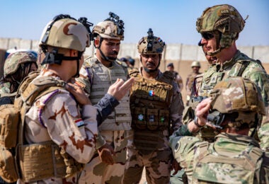 U.S. Army Staff Sgt. Erik Munchmore, assigned to Bravo Battery, 1st Battalion, 134th Field Artillery Regiment, 37th Infantry Brigade Combat Team, discusses weapon capabilities with Iraqi partner forces. Al Asad Air Base, Iraq, Feb. 27, 2023. Staff Sgt. Munchmore, is a part of the best M119A3 Howitzer team in the battalion within his section. (U.S. Army photo by Sgt. Julio Hernandez)