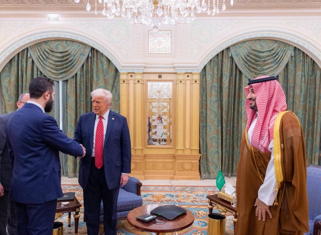 President of the United States Donald Trump shakes hands with Syrian President Ahmed al-Sharaa during a meeting in Riyadh on May 14 (Saudi Press Agency)